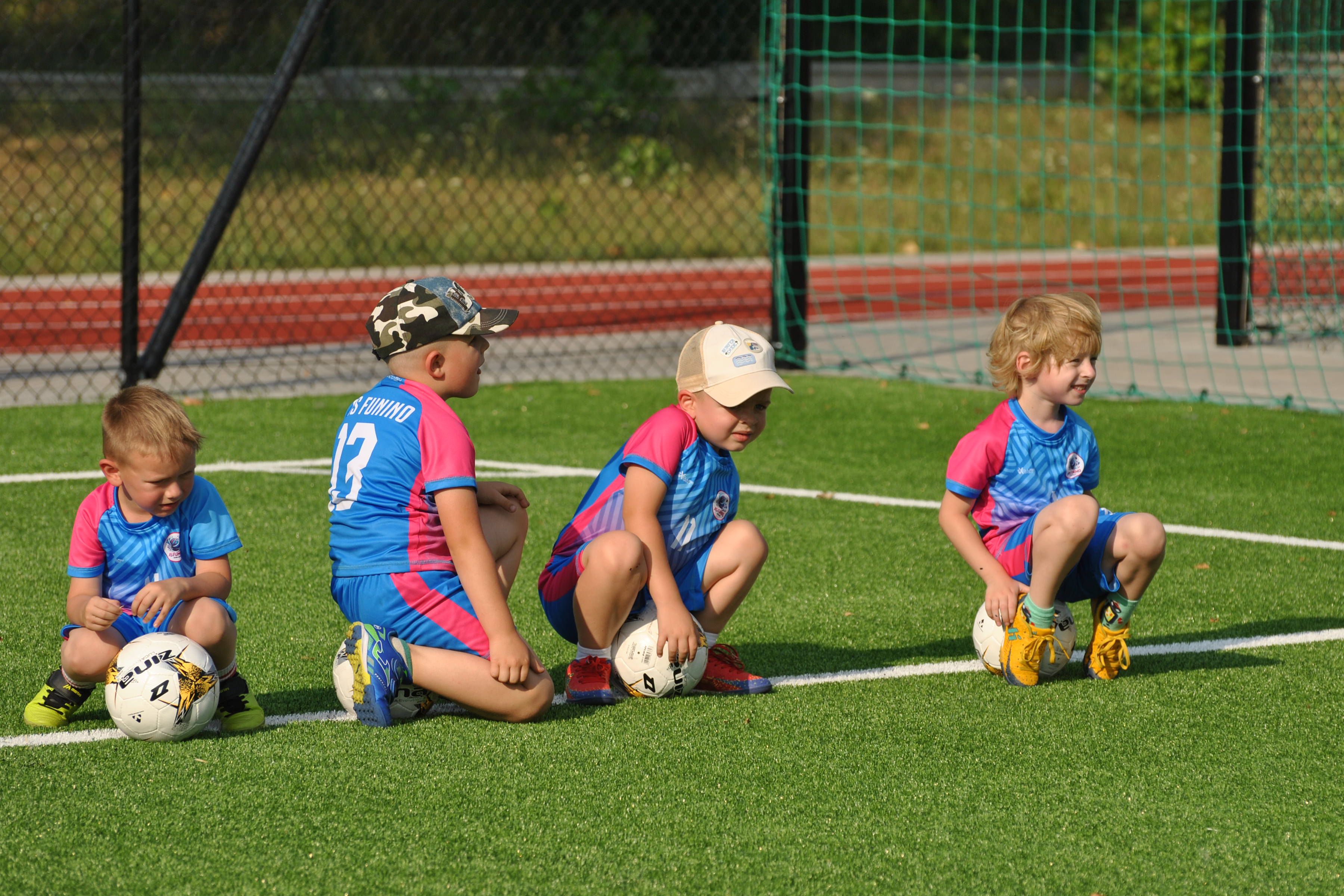Dzieci odpoczywają na piłkach w trakcie treningu Funino