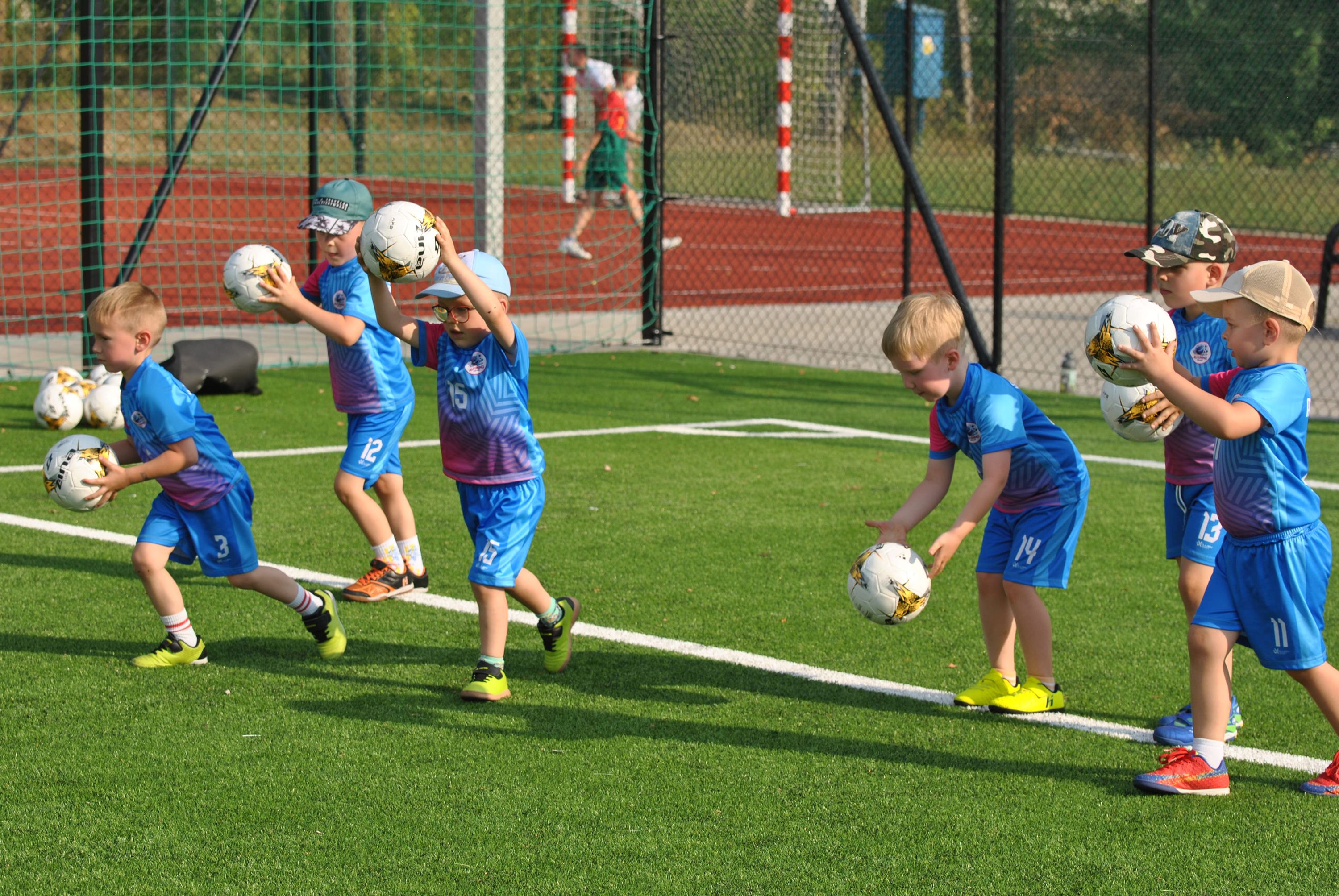 Grupa dzieci na treningu FUNiño na boisku szkolnym.